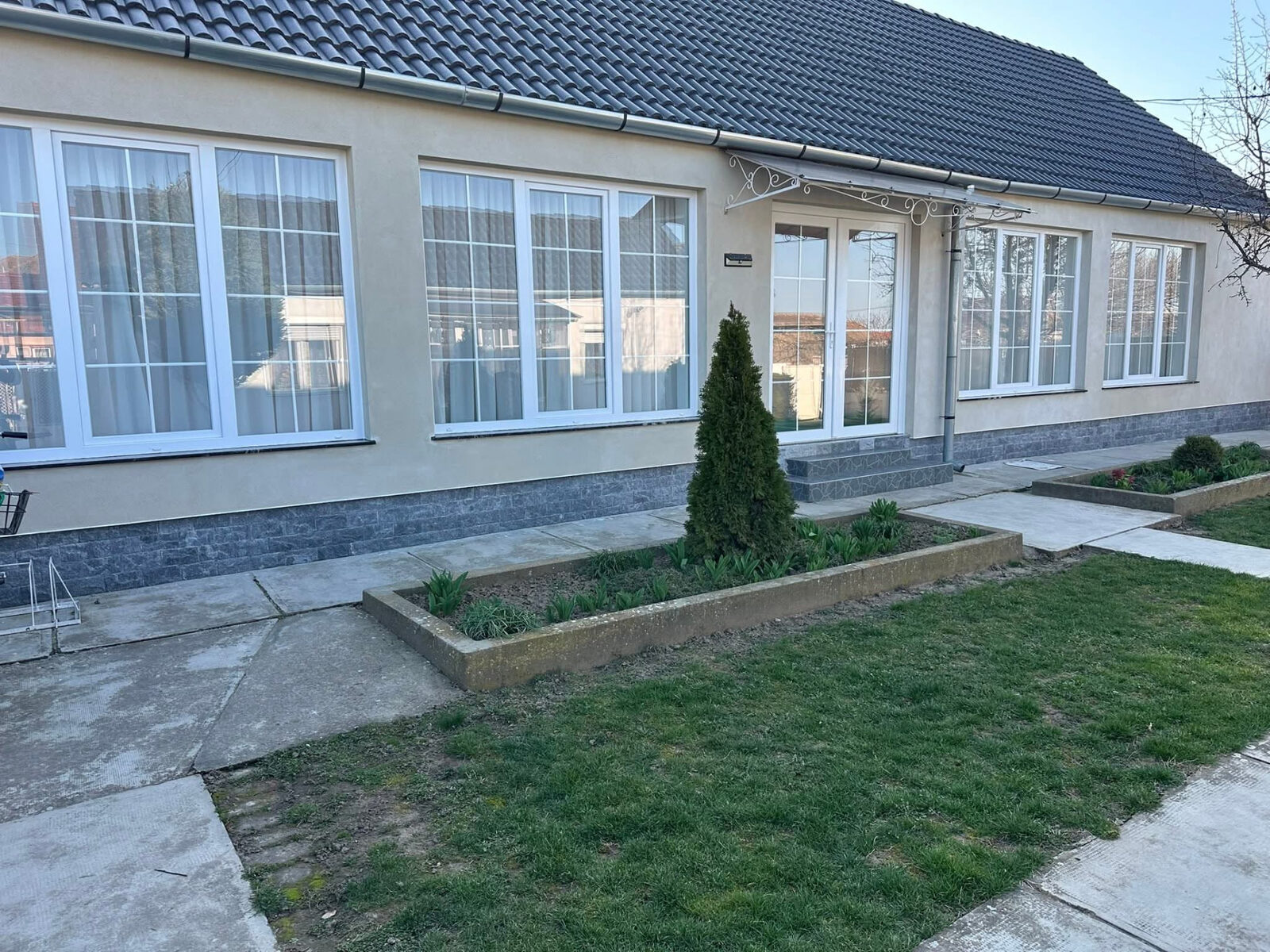 Weiße Kunststofffenster mit Sprossen an einem renovierten Wohnhaus